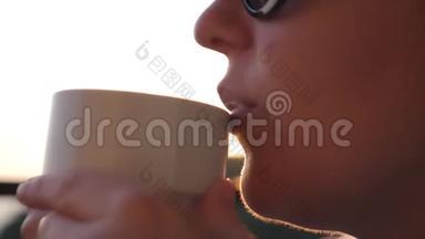 女人<strong>在阳光下</strong>喝咖啡，<strong>在阳光下</strong>户外，享受她的早晨咖啡。